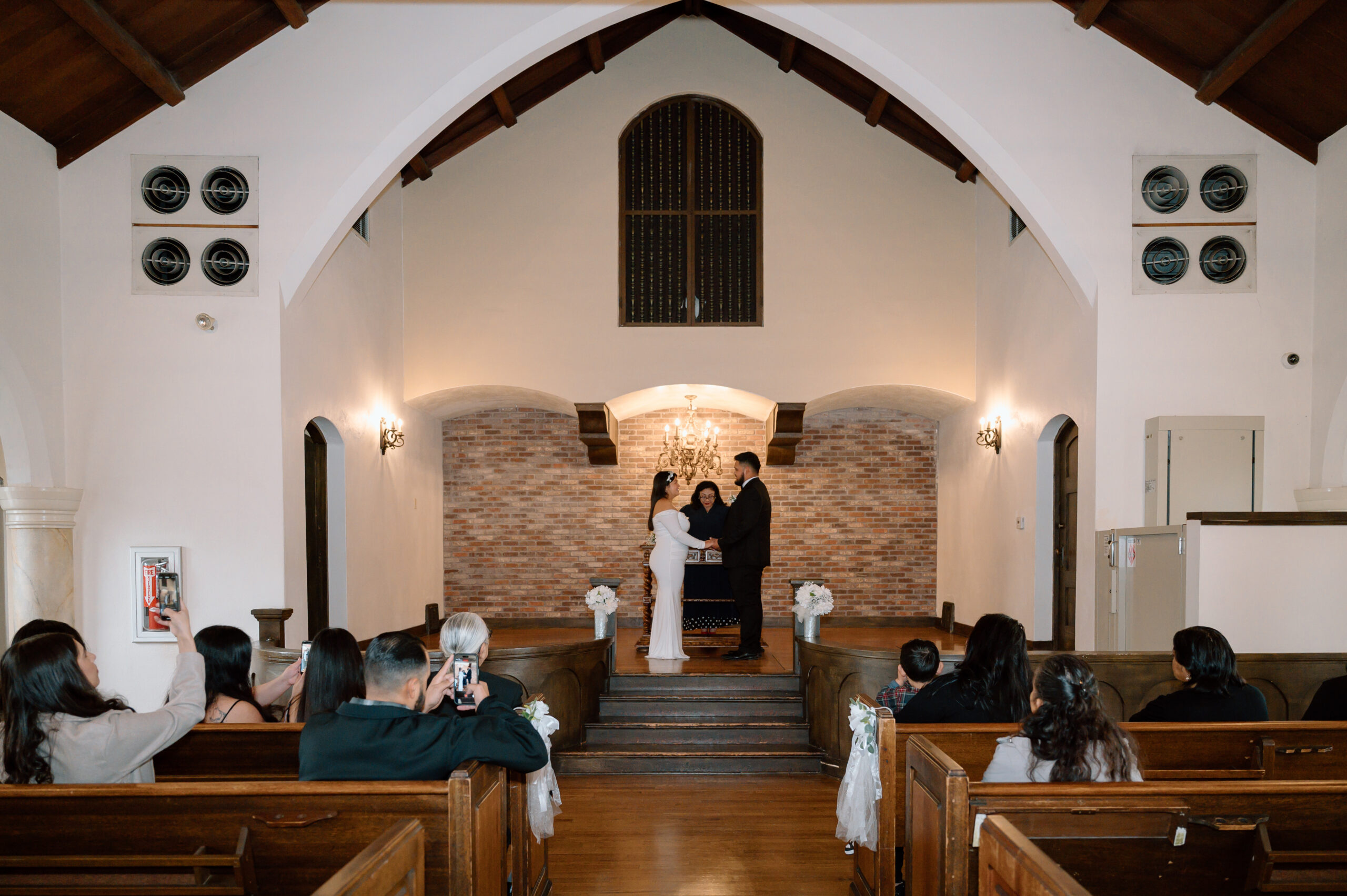 A bride and groom at the altar, sharing their vows inside Thee Olde Chapel in Riverside California