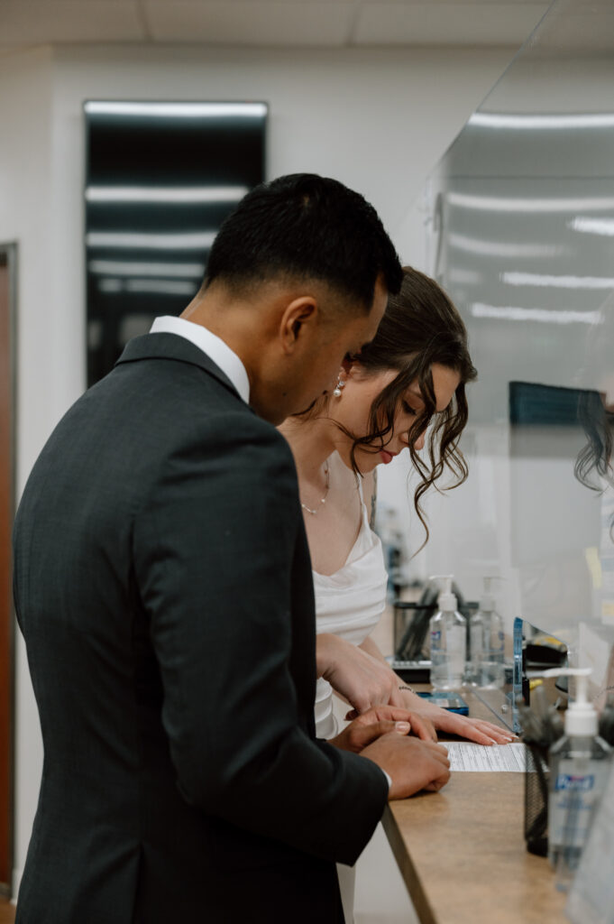 a bride signing her marriage license at the laguna hills civic center courhtouse